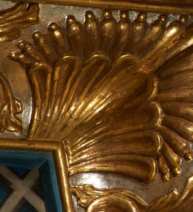 Zdjęcie nr 14: Ołtarz prostopadłościenny, murowany, w drewnianej obudowie, z drewnianą mensą. Antependium w kształcie leżącego prostokąta ujętego profilowaną ramą, dekorowane monogramem imienia MARIA w środku pola i symetrycznie rozłożonymi po bokach różanymi gałązkami. Na mensie ustawione architektoniczne tabernakulum. 
Nastawa w formie paludamentu podwiązanego po bokach sznurem z chwostami, lamowanego frędzlą, zwieńczonego baldachimem utworzonym z fragmentu wklęsło-wypukłego gzymsu z lambrekinem i rokokowym kartuszem. W polu paludamentu wnęka w kształcie stojącego prostokąta o wklęsłych górnych narożach w profilowanej ramie, ustawiona na cokole ujętym spływami wolutowymi. Wewnątrz obraz Matki Boskiej z Dzieciątkiem ujęty grubą ramą dekorowaną akantem i palmetami, ponad nim uskrzydlona główka anielska. Wnękę flankują dwa unoszące się putta, powyżej niej kartusz z monogramem Marii. Paludament dekorowany plastycznymi gwiazdami. Po bokach nastawy dwie bramki z otworami wejściowymi w formie stojącego prostokąta, zamkniętymi prostym gzymsem ze znajdującymi się powyżej postumentami dekorowanymi różami, na których stoją dwie figury aniołów. W górnej części, z obydwu stron nastawy poziome listwy konstrukcyjne mocujące całość retabulum do ścian bocznych prezbiterium, dekorowane są uskrzydlonymi główkami anielskimi z muszlami oraz roślinnymi festonami. Paludament polichromowany wewnątrz na biało, zewnątrz na niebiesko z pozłacanymi detalami.

