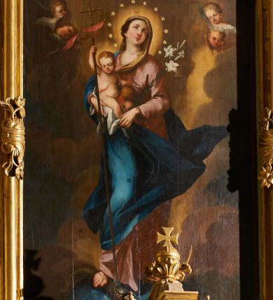 Zdjęcie nr 1: Obraz w formie stojącego prostokąta. W centrum przedstawienia znajduje się ukazana w całej postaci Maria, zwrócona w trzech czwartych w prawo, z rękami skierowanymi w przeciwną stronę; stoi na globie ziemskim, prawą stopą depcząc węża, lewą opierając na półksiężycu. Prawą ręką przytrzymuje Dzieciątko, lewą dłonią, w której trzyma gałązkę lilii, ujmuje jego stopę. Twarz Marii jest pełna o łagodnych rysach, bladej, zaróżowionej karnacji, o łukowato zarysowanej oprawie oczu, skierowanych do góry, małym nosie i pełnych ustach, z podkreśloną, wystającą brodą. Jej włosy, częściowo widoczne z prawej strony, ukryte są pod welonem. Dzieciątko siedzi na białej pieluszce, zwrócone w trzech czwartych w lewo, z głową skierowaną w przeciwną stronę. W prawej ręce trzyma czerwoną, rozwianą chorągiew z krzyżem, której drzewce sięgają stóp Marii, a zakończone są krzyżem, lewą rękę wspiera na jabłku królewskim opartym na kolanie. Jego twarz jest okrągła o pełnych policzkach, delikatnych rysach, okolona jasnymi, krótkimi włosami. Ciało pulchne, o jasnej karnacji, w partii podbrzusza przesłonięte bladoczerwoną tkaniną. Maria ubrana jest w bladoróżową suknię o dużym dekolcie, niebieski płaszcz zarzucony na prawe ramię i bok, który rozwiany jest w drugą stronę, ściśle przylegając do jej prawej nogi, tył i lewa strona głowy przekryte są bladożółtym welonem. Wokół głów obu postaci nimby, wokół głowy Marii wieniec z dwunastu gwiazd. Maria z Dzieciątkiem ukazana jest na tle zachmurzonego nieba z rozświetloną partią w prawej części kompozycji, w towarzystwie dwóch par uskrzydlonych główek anielskich w górnych narożach obrazu.
