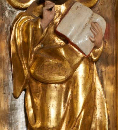 Zdjęcie nr 16: Tabernakulum architektoniczne, jednokondygnacyjne, pięcioosiowe. Osie wydzielone są sześcioma kanelowanymi kolumienkami na wysokich, profilowanych cokołach, z liściastymi kapitelami, podtrzymującymi profilowane belkowanie wyłamane na ich osiach. W polach pomiędzy kolumnami znajdują się nisze ujęte profilowaną ramą z uszakami. W czterech bocznych niszach, na trójdzielnych, profilowanych wspornikach stoją płaskorzeźbione postacie czterech ewangelistów na tle muszli palmetowych. Figurki są całopostaciowe, w ujęciu frontalnym, w złotych szatach, podtrzymują otwarte księgi, wskazując na tekst. Drzwiczki znajdują się na osi środkowej, zamknięte są półkoliście, płaskorzeźbione z przedstawieniem kielicha z koroną cierniową i z hostią w glorii promienistej. Kielich flankowany jest kłosami zbóż i winną latoroślą oraz winogronami. W partii belkowania płaskorzeźbiona dekoracja złożona z naprzemiennie ułożonych główek anielskich o złotych skrzydłach i płaskich rozetek. Tron wystawienia w formie baldachimu, z lambrekinem i chwostami, zwieńczony jest kulą z krzyżem, z podwieszonym z tyłu paludamentem podtrzymywanym przez parę puttów. Struktura polichromowana na biało, profile i detale pozłocone. 