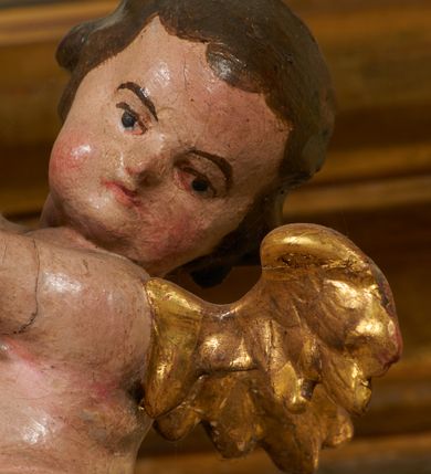 Zdjęcie nr 30: Tabernakulum architektoniczne, jednokondygnacyjne, pięcioosiowe. Osie wydzielone są sześcioma kanelowanymi kolumienkami na wysokich, profilowanych cokołach, z liściastymi kapitelami, podtrzymującymi profilowane belkowanie wyłamane na ich osiach. W polach pomiędzy kolumnami znajdują się nisze ujęte profilowaną ramą z uszakami. W czterech bocznych niszach, na trójdzielnych, profilowanych wspornikach stoją płaskorzeźbione postacie czterech ewangelistów na tle muszli palmetowych. Figurki są całopostaciowe, w ujęciu frontalnym, w złotych szatach, podtrzymują otwarte księgi, wskazując na tekst. Drzwiczki znajdują się na osi środkowej, zamknięte są półkoliście, płaskorzeźbione z przedstawieniem kielicha z koroną cierniową i z hostią w glorii promienistej. Kielich flankowany jest kłosami zbóż i winną latoroślą oraz winogronami. W partii belkowania płaskorzeźbiona dekoracja złożona z naprzemiennie ułożonych główek anielskich o złotych skrzydłach i płaskich rozetek. Tron wystawienia w formie baldachimu, z lambrekinem i chwostami, zwieńczony jest kulą z krzyżem, z podwieszonym z tyłu paludamentem podtrzymywanym przez parę puttów. Struktura polichromowana na biało, profile i detale pozłocone. 