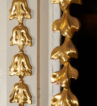 Zdjęcie nr 7: Nastawa architektoniczna, jednoosiowa, dwukondygnacyjna, ustawiona na niewielkim cokole, z dwoma prostopadłościennymi postumentami wydzielonymi po bokach. Ołtarz drewniany, prostopadłościenny, z drewnianą mensą. Antepedium w formie poziomego prostokąta ujętego profilowaną ramą, w polu malowany monogram IHS flankowany gałązkami lilii, u dołu girlanda kwiatowa. W predelli nastawy płycina w formie poziomego prostokąta poszerzonego na krótszych bokach za pomocą nadwieszonych łuków półkolistych, ze sceną modlitwy Chrystusa w Ogrójcu. Pierwsza kondygnacja ujęta parą kolumn stojących na postumentach, o skręconych trzonach dekorowanych ornamentem roślinnym. Podpory dźwigają belkowanie, o pełnych odcinkach nad kolumnami ustawionych pod kątem, z architrawem wyłamującym się schodkowo nad polem środkowym oraz gzymsem przyjmującym formę trzech boków z ośmioboku oraz przerwany, falisty przyczółek. Fryz belkowania ozdobiony jest ornamentem roślinnym, gzyms zaś dekorowany muszlą i zwisami kwiatowymi. Całe pole środkowe wypełnia nisza w kształcie stojącego prostokąta z wciętymi narożami, ujęta ramą ozdobioną ornamentem roślinnym, wewnątrz znajduje się rzeźbiarska grupa Ukrzyżowania na tle malowanego pejzażu. Pierwsza kondygnacja ujęta jest uszami utworzonymi z suchego akantu, w ich dolnej części postumenty dla figur św. Walentego i św. Jana Ewangelisty. Druga kondygnacja jest węższa od poprzedniej, flankowana parą ustawionych lekko pod kątem pilastrów dźwigających gzyms, dekorowanych w partii trzonów kampanulami. W polu obraz ze św. Wawrzyńcem w formie pionowego owalu w profilowanej ramie. Całość zwieńczona okiem Opatrzności na tle obłoków w glorii promienistej. Na belkowaniu niewielkie figury aniołów. Druga kondygnacja ujęta jest pionowymi rzędami kampanul. Struktura polichromowana w kolorze białym, z pozłacanymi profilami i elementami ornamentyki oraz srebrzonymi detalami. 