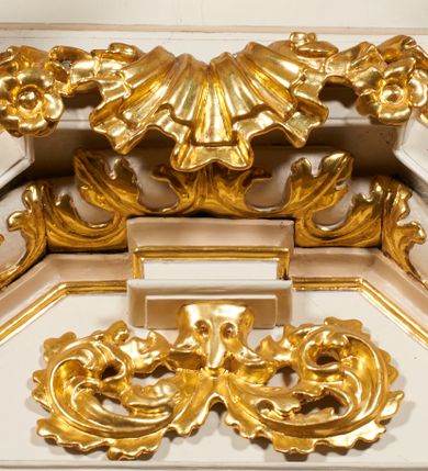 Zdjęcie nr 6: Nastawa architektoniczna, jednoosiowa, dwukondygnacyjna, ustawiona na niewielkim cokole, z dwoma prostopadłościennymi postumentami wydzielonymi po bokach. Ołtarz drewniany, prostopadłościenny, z drewnianą mensą. Antepedium w formie poziomego prostokąta ujętego profilowaną ramą, w polu malowany monogram IHS flankowany gałązkami lilii, u dołu girlanda kwiatowa. W predelli nastawy płycina w formie poziomego prostokąta poszerzonego na krótszych bokach za pomocą nadwieszonych łuków półkolistych, ze sceną modlitwy Chrystusa w Ogrójcu. Pierwsza kondygnacja ujęta parą kolumn stojących na postumentach, o skręconych trzonach dekorowanych ornamentem roślinnym. Podpory dźwigają belkowanie, o pełnych odcinkach nad kolumnami ustawionych pod kątem, z architrawem wyłamującym się schodkowo nad polem środkowym oraz gzymsem przyjmującym formę trzech boków z ośmioboku oraz przerwany, falisty przyczółek. Fryz belkowania ozdobiony jest ornamentem roślinnym, gzyms zaś dekorowany muszlą i zwisami kwiatowymi. Całe pole środkowe wypełnia nisza w kształcie stojącego prostokąta z wciętymi narożami, ujęta ramą ozdobioną ornamentem roślinnym, wewnątrz znajduje się rzeźbiarska grupa Ukrzyżowania na tle malowanego pejzażu. Pierwsza kondygnacja ujęta jest uszami utworzonymi z suchego akantu, w ich dolnej części postumenty dla figur św. Walentego i św. Jana Ewangelisty. Druga kondygnacja jest węższa od poprzedniej, flankowana parą ustawionych lekko pod kątem pilastrów dźwigających gzyms, dekorowanych w partii trzonów kampanulami. W polu obraz ze św. Wawrzyńcem w formie pionowego owalu w profilowanej ramie. Całość zwieńczona okiem Opatrzności na tle obłoków w glorii promienistej. Na belkowaniu niewielkie figury aniołów. Druga kondygnacja ujęta jest pionowymi rzędami kampanul. Struktura polichromowana w kolorze białym, z pozłacanymi profilami i elementami ornamentyki oraz srebrzonymi detalami. 