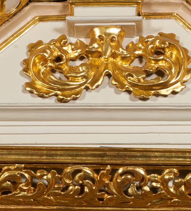 Zdjęcie nr 5: Nastawa architektoniczna, jednoosiowa, dwukondygnacyjna, ustawiona na niewielkim cokole, z dwoma prostopadłościennymi postumentami wydzielonymi po bokach. Ołtarz drewniany, prostopadłościenny, z drewnianą mensą. Antepedium w formie poziomego prostokąta ujętego profilowaną ramą, w polu malowany monogram IHS flankowany gałązkami lilii, u dołu girlanda kwiatowa. W predelli nastawy płycina w formie poziomego prostokąta poszerzonego na krótszych bokach za pomocą nadwieszonych łuków półkolistych, ze sceną modlitwy Chrystusa w Ogrójcu. Pierwsza kondygnacja ujęta parą kolumn stojących na postumentach, o skręconych trzonach dekorowanych ornamentem roślinnym. Podpory dźwigają belkowanie, o pełnych odcinkach nad kolumnami ustawionych pod kątem, z architrawem wyłamującym się schodkowo nad polem środkowym oraz gzymsem przyjmującym formę trzech boków z ośmioboku oraz przerwany, falisty przyczółek. Fryz belkowania ozdobiony jest ornamentem roślinnym, gzyms zaś dekorowany muszlą i zwisami kwiatowymi. Całe pole środkowe wypełnia nisza w kształcie stojącego prostokąta z wciętymi narożami, ujęta ramą ozdobioną ornamentem roślinnym, wewnątrz znajduje się rzeźbiarska grupa Ukrzyżowania na tle malowanego pejzażu. Pierwsza kondygnacja ujęta jest uszami utworzonymi z suchego akantu, w ich dolnej części postumenty dla figur św. Walentego i św. Jana Ewangelisty. Druga kondygnacja jest węższa od poprzedniej, flankowana parą ustawionych lekko pod kątem pilastrów dźwigających gzyms, dekorowanych w partii trzonów kampanulami. W polu obraz ze św. Wawrzyńcem w formie pionowego owalu w profilowanej ramie. Całość zwieńczona okiem Opatrzności na tle obłoków w glorii promienistej. Na belkowaniu niewielkie figury aniołów. Druga kondygnacja ujęta jest pionowymi rzędami kampanul. Struktura polichromowana w kolorze białym, z pozłacanymi profilami i elementami ornamentyki oraz srebrzonymi detalami. 