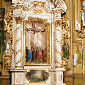 Zdjęcie nr 1: Nastawa architektoniczna, jednoosiowa, dwukondygnacyjna, ustawiona na niewielkim cokole, z dwoma prostopadłościennymi postumentami wydzielonymi po bokach. Ołtarz drewniany, prostopadłościenny, z drewnianą mensą. Antepedium w formie poziomego prostokąta ujętego profilowaną ramą, w polu malowany monogram IHS flankowany gałązkami lilii, u dołu girlanda kwiatowa. W predelli nastawy płycina w formie poziomego prostokąta poszerzonego na krótszych bokach za pomocą nadwieszonych łuków półkolistych, ze sceną modlitwy Chrystusa w Ogrójcu. Pierwsza kondygnacja ujęta parą kolumn stojących na postumentach, o skręconych trzonach dekorowanych ornamentem roślinnym. Podpory dźwigają belkowanie, o pełnych odcinkach nad kolumnami ustawionych pod kątem, z architrawem wyłamującym się schodkowo nad polem środkowym oraz gzymsem przyjmującym formę trzech boków z ośmioboku oraz przerwany, falisty przyczółek. Fryz belkowania ozdobiony jest ornamentem roślinnym, gzyms zaś dekorowany muszlą i zwisami kwiatowymi. Całe pole środkowe wypełnia nisza w kształcie stojącego prostokąta z wciętymi narożami, ujęta ramą ozdobioną ornamentem roślinnym, wewnątrz znajduje się rzeźbiarska grupa Ukrzyżowania na tle malowanego pejzażu. Pierwsza kondygnacja ujęta jest uszami utworzonymi z suchego akantu, w ich dolnej części postumenty dla figur św. Walentego i św. Jana Ewangelisty. Druga kondygnacja jest węższa od poprzedniej, flankowana parą ustawionych lekko pod kątem pilastrów dźwigających gzyms, dekorowanych w partii trzonów kampanulami. W polu obraz ze św. Wawrzyńcem w formie pionowego owalu w profilowanej ramie. Całość zwieńczona okiem Opatrzności na tle obłoków w glorii promienistej. Na belkowaniu niewielkie figury aniołów. Druga kondygnacja ujęta jest pionowymi rzędami kampanul. Struktura polichromowana w kolorze białym, z pozłacanymi profilami i elementami ornamentyki oraz srebrzonymi detalami. 