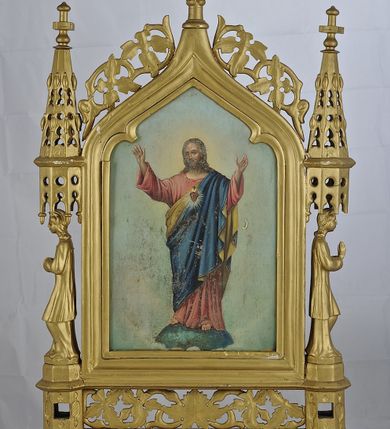 Zdjęcie nr 1: Feretron obustronny, z przedstawieniem Najświętszego Serca Pana Jezusa malowanym na blasze i na odwrocie Matki Boskiej Nieustającej Pomocy malowanej na drewnie. Rama w kształcie pionowego prostokąta, zamkniętego łukiem w ostry grzbiet. Przy dolnej krawędzi umieszczone ażurowe zwoje ornamentu roślinnego, ujęte postumentami, w których wydrążono prostokątne otwory do wsuwania drążków. Feretron ustawiony na dwóch nóżkach. Po bokach ustawione profilem postacie na konsolach, ponad nimi znajdują się ażurowe baldachimy ze sterczynami. Rama łuku wieńczącego ozdobiona stylizowanym astwerkiem. Całość zwieńczona jest krzyżem. 
Na awersie obrazu przedstawienie Chrystusa w całej postaci, stojącego na globie pośród obłoków, zwróconego w trzech czwartych w prawo, z obiema rękoma uniesionymi ku górze. Jego twarz jest pociągła, o łagodnych rysach, okolona brodą i włosami opadającymi na ramiona. Ubrany jest w czerwoną tunikę, ze złotą lamówką oraz niebieski płaszcz, o żółtej podszewce. Na jego piersi znajduje się gorejące serce w glorii promienistej. Z drugiej strony feretronu przedstawienie Matki Boskiej Nieustającej Pomocy o ikonografii zgodnej ze schematem. 
