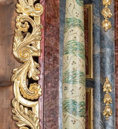 Zdjęcie nr 7: Ołtarz przyścienny, architektoniczny, jednokondygnacyjny, jednoosiowy ze zwieńczeniem. Mensa prostopadłościenna, drewniana, ustawiona na cokole, zamknięta profilowanym gzymsem. Antepedium zdobione malowaną płyciną w kształcie leżącego prostokąta o wklęsłych narożach i zryzalitowanym górnym i dolnym boku. W polu monogram IHS otoczony wieńcem z kłosów zbóż. Tło jasnoniebieskie, fakturowane w ciemnoszare plamki. Nastawa ołtarzowa ustawiona na niskim cokole o wysuniętych do przodu impostach, na których ustawiona jest para kolumn, wspierających przerwane belkowanie i wolutowy przyczółek. Pośrodku w ramie ozdobionej płaskorzeźbionymi liśćmi obraz Matki Boskiej Różańcowej w kształcie stojącego prostokąta, zamkniętego łukiem wklęsło-wypukłym z uskokami. Po bokach obrazu zwisy z kamapnul. Fryz dekorowany liśćmi akantu i rozetkami. Na tle kolumn prostokątne płyciny. W zwieńczeniu monogram maryjny na tle promienistej glorii z czterema uskrzydlonymi główkami anielskimi. Po bokach ołtarza akantowe uszy, przeplecione karbowaną wstęgą. Imposty w partii cokołu zdobione płycinami w kształcie niewielkich prostokątów, wypełnionych liśćmi akantu. Struktura malowana na kolor ciemnoniebieski i fakturowana w szare plamki, trzony kolumn marmoryzowane na kolor zielono-beżowy, profilowania na kolor bordowy, detale i ornamentyka złocone. 