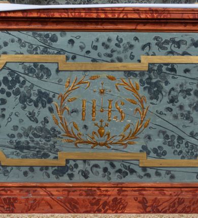 Zdjęcie nr 9: Ołtarz przyścienny, architektoniczny, jednokondygnacyjny, jednoosiowy ze zwieńczeniem. Mensa prostopadłościenna, drewniana, ustawiona na cokole, zamknięta profilowanym gzymsem. Antepedium zdobione malowaną płyciną w kształcie leżącego prostokąta o wklęsłych narożach i zryzalitowanym górnym i dolnym boku. W polu monogram IHS otoczony wieńcem z kłosów zbóż. Tło jasnoniebieskie, fakturowane w ciemnoszare plamki. Nastawa ołtarzowa ustawiona na niskim cokole o wysuniętych do przodu impostach, na których ustawiona jest para kolumn, wspierających przerwane belkowanie i wolutowy przyczółek. Pośrodku w ramie ozdobionej płaskorzeźbionymi liśćmi obraz Matki Boskiej Różańcowej w kształcie stojącego prostokąta, zamkniętego łukiem wklęsło-wypukłym z uskokami. Po bokach obrazu zwisy z kamapnul. Fryz dekorowany liśćmi akantu i rozetkami. Na tle kolumn prostokątne płyciny. W zwieńczeniu monogram maryjny na tle promienistej glorii z czterema uskrzydlonymi główkami anielskimi. Po bokach ołtarza akantowe uszy, przeplecione karbowaną wstęgą. Imposty w partii cokołu zdobione płycinami w kształcie niewielkich prostokątów, wypełnionych liśćmi akantu. Struktura malowana na kolor ciemnoniebieski i fakturowana w szare plamki, trzony kolumn marmoryzowane na kolor zielono-beżowy, profilowania na kolor bordowy, detale i ornamentyka złocone. 