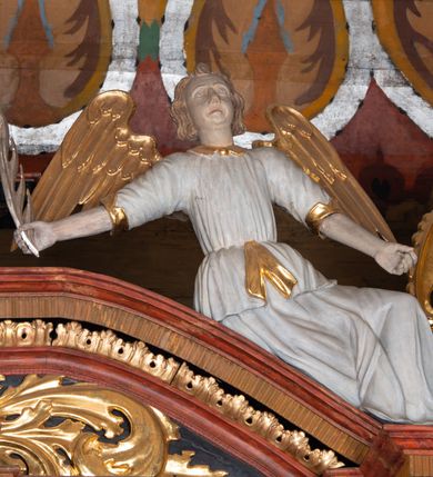 Zdjęcie nr 6: Ołtarz trójosiowy, dwukondygnacyjny z bramkami o formach architektonicznych, uszaty. Mensa murowana, prostopadłościenna z drewnianym antepedium ujętym profilowaną ramą z malowaną dekoracją roślinną. W polu malowane na płótnie przedstawienie adoracji Najświętszego Sakramentu. Tabernakulum w formie prostopadłościanu, o wypukłej ściance frontowej, ujętej pilastrami o kapitelach w formie akantowych konsol podtrzymujących pełne belkowanie. Na trzonach owalne lustra w akantowych ramach. W zwieńczeniu dwie uskrzydlone główki anielskie. Na metalowych drzwiczkach krucyfiks oraz kielich z hostią w otoczeniu winnych gron i kłosów (na odwrociu). Naroża tabernakulum flankuje para aniołów ustawionych na wolutowych konsolach. Nastawa umieszczona na wysokim cokole z bramkami mieszczącymi obrazy Chrystusa w typie Ecce Homo (z lewej) oraz Matki Boskiej Bolesnej (z prawej). Cokół artykułowany wysokimi postumentami, na których ustawione są kolumny. W polach postumentów złocona dekoracja akantowa. Kondygnacja pierwsza trójosiowa, artykułowana złoconymi kolumnami o korynckich kapitelach, ujęta srebrzonymi akantowymi uszami (suchy akant). Kolumny dźwigają pełne belkowanie, wyłamane na osiach podpór oraz odcinki przyczółka, na których siedzą figury aniołów w białych szatach. Dodatkowo, w osiach kolumn umieszczone mniejsze figury klęczących aniołów (osie wewnętrzne) oraz marmoryzowane, owalne kartusze ujęte złoconymi ramami z ornamentem małżowinowo-chrząstkowym (osie zewnętrzne). W partii fryzu złocone rozetki oraz marmoryzowane, owalne kartusze ujęte złoconym akantem. Gzyms profilowany, dekorowany dodatkowo złoconym kimationem. W polu środkowym prostokątny obraz przedstawiający Rodzinę Marii. Na zasuwie umieszczony obraz z wizerunkiem św. Katarzyny Aleksandryjskiej. Powyżej, w osi ołtarza obraz ze sceną Koronacji Marii, o nieregularnym kształcie w akantowej ramie, zwieńczonej koroną. W osiach bocznych umieszczone skrzydła boczne dawnego, gotyckiego tryptyku z wizerunkami św. Jana Chrzciciela i św. Barbary (z lewej) oraz św. Stanisława biskupa i św. Katarzyny Aleksandryjskiej (z prawej). Zwieńczenie ołtarza w formie edikuli ujętej złoconymi, korynckimi kolumnami oraz złoconymi, akantowymi uszami. Po bokach niewielkie figury klęczących aniołów. Podpory dźwigają wyłamane belkowanie dekorowane kimationem i rozetkami, łukowato wyginające się w osi ołtarza. W polu obraz w kształcie stojącego prostokąta zamkniętego łukiem półkolistym ze sceną Zwiastowania. Całość zwieńczona srebrzonym baldachimem z podwieszonej tkaniny przewiązanej złotym sznurem ze złoconą koroną umieszczoną na szczycie. Struktura ołtarza marmoryzowana w odcieniu ciemnoszarym, profile i płyciny na filarach marmoryzowane w kolorze bordowym, ornamentyka złocona i posrebrzana.