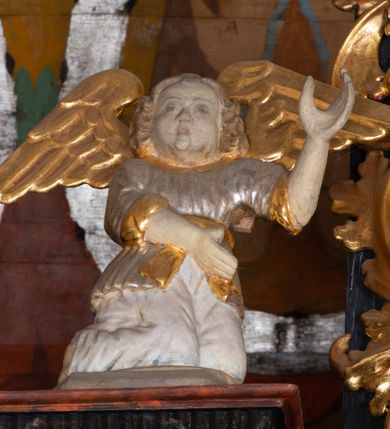 Zdjęcie nr 11: Ołtarz trójosiowy, dwukondygnacyjny z bramkami o formach architektonicznych, uszaty. Mensa murowana, prostopadłościenna z drewnianym antepedium ujętym profilowaną ramą z malowaną dekoracją roślinną. W polu malowane na płótnie przedstawienie adoracji Najświętszego Sakramentu. Tabernakulum w formie prostopadłościanu, o wypukłej ściance frontowej, ujętej pilastrami o kapitelach w formie akantowych konsol podtrzymujących pełne belkowanie. Na trzonach owalne lustra w akantowych ramach. W zwieńczeniu dwie uskrzydlone główki anielskie. Na metalowych drzwiczkach krucyfiks oraz kielich z hostią w otoczeniu winnych gron i kłosów (na odwrociu). Naroża tabernakulum flankuje para aniołów ustawionych na wolutowych konsolach. Nastawa umieszczona na wysokim cokole z bramkami mieszczącymi obrazy Chrystusa w typie Ecce Homo (z lewej) oraz Matki Boskiej Bolesnej (z prawej). Cokół artykułowany wysokimi postumentami, na których ustawione są kolumny. W polach postumentów złocona dekoracja akantowa. Kondygnacja pierwsza trójosiowa, artykułowana złoconymi kolumnami o korynckich kapitelach, ujęta srebrzonymi akantowymi uszami (suchy akant). Kolumny dźwigają pełne belkowanie, wyłamane na osiach podpór oraz odcinki przyczółka, na których siedzą figury aniołów w białych szatach. Dodatkowo, w osiach kolumn umieszczone mniejsze figury klęczących aniołów (osie wewnętrzne) oraz marmoryzowane, owalne kartusze ujęte złoconymi ramami z ornamentem małżowinowo-chrząstkowym (osie zewnętrzne). W partii fryzu złocone rozetki oraz marmoryzowane, owalne kartusze ujęte złoconym akantem. Gzyms profilowany, dekorowany dodatkowo złoconym kimationem. W polu środkowym prostokątny obraz przedstawiający Rodzinę Marii. Na zasuwie umieszczony obraz z wizerunkiem św. Katarzyny Aleksandryjskiej. Powyżej, w osi ołtarza obraz ze sceną Koronacji Marii, o nieregularnym kształcie w akantowej ramie, zwieńczonej koroną. W osiach bocznych umieszczone skrzydła boczne dawnego, gotyckiego tryptyku z wizerunkami św. Jana Chrzciciela i św. Barbary (z lewej) oraz św. Stanisława biskupa i św. Katarzyny Aleksandryjskiej (z prawej). Zwieńczenie ołtarza w formie edikuli ujętej złoconymi, korynckimi kolumnami oraz złoconymi, akantowymi uszami. Po bokach niewielkie figury klęczących aniołów. Podpory dźwigają wyłamane belkowanie dekorowane kimationem i rozetkami, łukowato wyginające się w osi ołtarza. W polu obraz w kształcie stojącego prostokąta zamkniętego łukiem półkolistym ze sceną Zwiastowania. Całość zwieńczona srebrzonym baldachimem z podwieszonej tkaniny przewiązanej złotym sznurem ze złoconą koroną umieszczoną na szczycie. Struktura ołtarza marmoryzowana w odcieniu ciemnoszarym, profile i płyciny na filarach marmoryzowane w kolorze bordowym, ornamentyka złocona i posrebrzana.