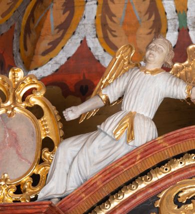 Zdjęcie nr 5: Ołtarz trójosiowy, dwukondygnacyjny z bramkami o formach architektonicznych, uszaty. Mensa murowana, prostopadłościenna z drewnianym antepedium ujętym profilowaną ramą z malowaną dekoracją roślinną. W polu malowane na płótnie przedstawienie adoracji Najświętszego Sakramentu. Tabernakulum w formie prostopadłościanu, o wypukłej ściance frontowej, ujętej pilastrami o kapitelach w formie akantowych konsol podtrzymujących pełne belkowanie. Na trzonach owalne lustra w akantowych ramach. W zwieńczeniu dwie uskrzydlone główki anielskie. Na metalowych drzwiczkach krucyfiks oraz kielich z hostią w otoczeniu winnych gron i kłosów (na odwrociu). Naroża tabernakulum flankuje para aniołów ustawionych na wolutowych konsolach. Nastawa umieszczona na wysokim cokole z bramkami mieszczącymi obrazy Chrystusa w typie Ecce Homo (z lewej) oraz Matki Boskiej Bolesnej (z prawej). Cokół artykułowany wysokimi postumentami, na których ustawione są kolumny. W polach postumentów złocona dekoracja akantowa. Kondygnacja pierwsza trójosiowa, artykułowana złoconymi kolumnami o korynckich kapitelach, ujęta srebrzonymi akantowymi uszami (suchy akant). Kolumny dźwigają pełne belkowanie, wyłamane na osiach podpór oraz odcinki przyczółka, na których siedzą figury aniołów w białych szatach. Dodatkowo, w osiach kolumn umieszczone mniejsze figury klęczących aniołów (osie wewnętrzne) oraz marmoryzowane, owalne kartusze ujęte złoconymi ramami z ornamentem małżowinowo-chrząstkowym (osie zewnętrzne). W partii fryzu złocone rozetki oraz marmoryzowane, owalne kartusze ujęte złoconym akantem. Gzyms profilowany, dekorowany dodatkowo złoconym kimationem. W polu środkowym prostokątny obraz przedstawiający Rodzinę Marii. Na zasuwie umieszczony obraz z wizerunkiem św. Katarzyny Aleksandryjskiej. Powyżej, w osi ołtarza obraz ze sceną Koronacji Marii, o nieregularnym kształcie w akantowej ramie, zwieńczonej koroną. W osiach bocznych umieszczone skrzydła boczne dawnego, gotyckiego tryptyku z wizerunkami św. Jana Chrzciciela i św. Barbary (z lewej) oraz św. Stanisława biskupa i św. Katarzyny Aleksandryjskiej (z prawej). Zwieńczenie ołtarza w formie edikuli ujętej złoconymi, korynckimi kolumnami oraz złoconymi, akantowymi uszami. Po bokach niewielkie figury klęczących aniołów. Podpory dźwigają wyłamane belkowanie dekorowane kimationem i rozetkami, łukowato wyginające się w osi ołtarza. W polu obraz w kształcie stojącego prostokąta zamkniętego łukiem półkolistym ze sceną Zwiastowania. Całość zwieńczona srebrzonym baldachimem z podwieszonej tkaniny przewiązanej złotym sznurem ze złoconą koroną umieszczoną na szczycie. Struktura ołtarza marmoryzowana w odcieniu ciemnoszarym, profile i płyciny na filarach marmoryzowane w kolorze bordowym, ornamentyka złocona i posrebrzana.