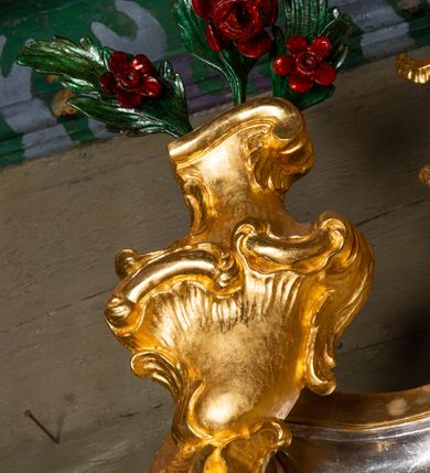 Zdjęcie nr 7: Nastawa ołtarzowa drewniana, architektoniczna, jednoosiowa, jednokondygnacyjna ze zwieńczeniem. Mensa w typie sarkofagowym, wklęsło-wypukła, zwężająca się ku dołowi, zamknięta gzymsem; naroża ujęte fragmentami rocaille'u, na froncie rocaille’owy kartusz; portatyl z marmuru dębnickiego. Na mensie ustawiono tabernakulum w formie prostopadłościennej skrzynki, o wypukłej ściance frontowej, która jest ujęta w narożach ustawionymi pod kątem pilastrami na cokołach, których trzony przyjmują formę spływów wolutowych. Podpory dźwigają gzyms, opasujący całą skrzynkę, wyłamany na ich osi. Drzwiczki w formie stojącego prostokąta zamkniętego łukiem nadwieszonym, w polu nisza z płaskorzeźbionym przedstawieniem kielicha z hostią w glorii. Drzwiczki zostały ujęte płyciną w formie stojącego prostokąta zamkniętego łukiem kotarowym dwudzielnym. Na tabernakulum tron wystawienia w postaci cokołu. Nastawa ołtarzowa została posadowiona na wysokim cokole, przyjmującym po bokach formę wolut stanowiących podstawę dla figur św. Piotra z prawej i św. Pawła z lewej strony. Jest ujęta parą pilastrów ustawionych pod katem względem lica, których trzony u góry przechodzą w woluty. Podpory dźwigają imposty. W polu środkowym płycina w formie stojącego prostokąta zamkniętego łukiem półkolistym nadwieszonym z uskokiem, w której znajduje się mniejsza nisza o tej samej formie, ujęta ramą, wypełniona obrazem Matki Boskiej z Dzieciątkiem. Zwieńczenie w formie zbliżonej do trapezu, ujętego podwójnymi spływami wolutowymi, zamkniętego falistym gzymsem. Całość wieńczy rzeźbiona gołębica Ducha Świętego w glorii promienistej. Trzony pilastrów nastawy dekorowane zwisami z różanych gałązek. Płycina pola środkowego ujęta rocaille'em, który ponad łukiem, w polu zwieńczenia, tworzy medalion z uskrzydloną główką anielską, otoczony dużymi różanymi gałązkami; w polu środkowym cztery uskrzydlone główki anielskie. Kondygnacja flankowana uszami utworzonymi z płomienistego rocaille'u i różanych gałązek. Na belkowaniu dwa rokokowe wazony z różami. Zwieńczenie ujęte falbanką, rocaille'em i różanymi gałązkami. Struktura w całości marmoryzowana w kolorze szaroniebieskim, ornamentyki i profile złocone i srebrzone, ukwiecone gałązki laserunkowe.