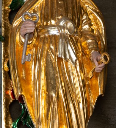 Zdjęcie nr 3: Nastawa ołtarzowa drewniana, architektoniczna, jednoosiowa, jednokondygnacyjna ze zwieńczeniem. Mensa w typie sarkofagowym, wklęsło-wypukła, zwężająca się ku dołowi, zamknięta gzymsem; naroża ujęte fragmentami rocaille'u, na froncie rocaille’owy kartusz; portatyl z marmuru dębnickiego. Na mensie ustawiono tabernakulum w formie prostopadłościennej skrzynki, o wypukłej ściance frontowej, która jest ujęta w narożach ustawionymi pod kątem pilastrami na cokołach, których trzony przyjmują formę spływów wolutowych. Podpory dźwigają gzyms, opasujący całą skrzynkę, wyłamany na ich osi. Drzwiczki w formie stojącego prostokąta zamkniętego łukiem nadwieszonym, w polu nisza z płaskorzeźbionym przedstawieniem kielicha z hostią w glorii. Drzwiczki zostały ujęte płyciną w formie stojącego prostokąta zamkniętego łukiem kotarowym dwudzielnym. Na tabernakulum tron wystawienia w postaci cokołu. Nastawa ołtarzowa została posadowiona na wysokim cokole, przyjmującym po bokach formę wolut stanowiących podstawę dla figur św. Piotra z prawej i św. Pawła z lewej strony. Jest ujęta parą pilastrów ustawionych pod katem względem lica, których trzony u góry przechodzą w woluty. Podpory dźwigają imposty. W polu środkowym płycina w formie stojącego prostokąta zamkniętego łukiem półkolistym nadwieszonym z uskokiem, w której znajduje się mniejsza nisza o tej samej formie, ujęta ramą, wypełniona obrazem Matki Boskiej z Dzieciątkiem. Zwieńczenie w formie zbliżonej do trapezu, ujętego podwójnymi spływami wolutowymi, zamkniętego falistym gzymsem. Całość wieńczy rzeźbiona gołębica Ducha Świętego w glorii promienistej. Trzony pilastrów nastawy dekorowane zwisami z różanych gałązek. Płycina pola środkowego ujęta rocaille'em, który ponad łukiem, w polu zwieńczenia, tworzy medalion z uskrzydloną główką anielską, otoczony dużymi różanymi gałązkami; w polu środkowym cztery uskrzydlone główki anielskie. Kondygnacja flankowana uszami utworzonymi z płomienistego rocaille'u i różanych gałązek. Na belkowaniu dwa rokokowe wazony z różami. Zwieńczenie ujęte falbanką, rocaille'em i różanymi gałązkami. Struktura w całości marmoryzowana w kolorze szaroniebieskim, ornamentyki i profile złocone i srebrzone, ukwiecone gałązki laserunkowe.