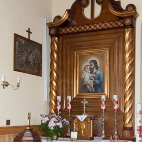 Zdjęcie nr 1: Nastawa ołtarzowa przyścienna, architektoniczna, jednokondygnacyjna ze zwieńczeniem. Mensa skrzyniowa, prostopadłościenna, ustawiona na jednym stopniu. Antepedium trójpolowe, obramione profilowanymi listwami, w narożach ujęte skręconymi, złoconymi kolumnami. W środkowym polu hierogram IHS, w bocznych motywy kwiatu dziewięćsiłu. Portatyl w formie kamiennej płytki. Tabernakulum w kształcie niewielkiej prostopadłościennej szafki, ujęte w narożach skręconymi kolumnami o kapitelach kostkowych, podtrzymujących profilowany gzyms. Od frontu drzwiczki w formie prostokąta zamkniętego łukiem odcinkowym, z rytą dekoracją roślinną i aplikowanym złoconym kielichem. Nastawa płaska, flankowana skręconymi, złoconymi kolumnami, ustawionymi na cokołach, dekorowanych rozetką. Kolumny zwieńczone kostkowymi kapitelami z rozetkami, nad którymi przerwany przyczółek. Nad polem środkowym zredukowane belkowanie, z fryzem zdobionym ukośną kratką. Zwieńczenie ujęte dwoma wolutami z uskokiem, dekorowanymi na krańcach rozetkami pomiędzy którymi półokrągłe wycięcie i łaciński krzyż. W polu głównym obraz św. Józefa z Dzieciątkiem w prostokątnej ramie, dookoła obwiedziony szerokim profilowaniem. Struktura bejcowana, pokryta lakierem, detale i kolumny złocone. 
