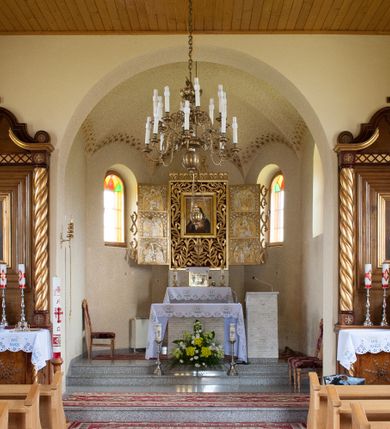 Zdjęcie nr 6: Nastawa ołtarzowa przyścienna, architektoniczna, jednokondygnacyjna ze zwieńczeniem. Mensa skrzyniowa, prostopadłościenna, ustawiona na jednym stopniu. Antepedium trójpolowe, obramione profilowanymi listwami, w narożach ujęte skręconymi, złoconymi kolumnami. W środkowym polu hierogram IHS, w bocznych motywy kwiatu dziewięćsiłu. Portatyl w formie kamiennej płytki. Tabernakulum w kształcie niewielkiej prostopadłościennej szafki, ujęte w narożach skręconymi kolumnami o kapitelach kostkowych, podtrzymujących profilowany gzyms. Od frontu drzwiczki w formie prostokąta zamkniętego łukiem odcinkowym, z rytą dekoracją roślinną i aplikowanym złoconym kielichem. Nastawa płaska, flankowana skręconymi, złoconymi kolumnami, ustawionymi na cokołach, dekorowanych rozetką. Kolumny zwieńczone kostkowymi kapitelami z rozetkami, nad którymi przerwany przyczółek. Nad polem środkowym zredukowane belkowanie, z fryzem zdobionym ukośną kratką. Zwieńczenie ujęte dwoma wolutami z uskokiem, dekorowanymi na krańcach rozetkami pomiędzy którymi półokrągłe wycięcie i łaciński krzyż. W polu głównym obraz św. Józefa z Dzieciątkiem w prostokątnej ramie, dookoła obwiedziony szerokim profilowaniem. Struktura bejcowana, pokryta lakierem, detale i kolumny złocone. 
