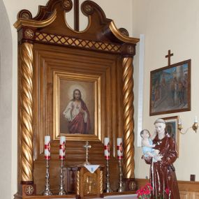 Zdjęcie nr 1: Nastawa ołtarzowa przyścienna, architektoniczna, jednokondygnacyjna ze zwieńczeniem. Mensa skrzyniowa, prostopadłościenna, ustawiona na jednym stopniu. Antepedium trójpolowe, obramione profilowanymi listwami, w narożach ujęte skręconymi, złoconymi kolumnami. W środkowym polu hierogram IHS, w bocznych motywy kwiatu dziewięćsiłu. Portatyl w formie kamiennej płytki. Tabernakulum w kształcie niewielkiej prostopadłościennej szafki, ujęte w narożach skręconymi kolumnami o kapitelach kostkowych, podtrzymujących profilowany gzyms. Od frontu drzwiczki w formie prostokąta zamkniętego łukiem odcinkowym, z rytą dekoracją roślinną i aplikowanym złoconym kielichem. Nastawa płaska, flankowana skręconymi, złoconymi kolumnami, ustawionymi na cokołach, dekorowanych rozetką. Kolumny zwieńczone kostkowymi kapitelami, ozdobionymi rozetką, nad którymi przerwany przyczółek. Nad polem środkowym zredukowane belkowanie, z fryzem zdobionym ukośną kratką. Zwieńczenie ujęte dwoma wolutami z uskokiem, dekorowanymi na krańcach rozetkami, pomiędzy którymi półokrągłe wycięcie i łaciński krzyż. W polu głównym obraz „Najświętsze Serce Jezusa” w prostokątnej ramie, dookoła obwiedziony szerokim profilowaniem. Struktura bejcowana, pokryta lakierem, detale i kolumny złocone. 