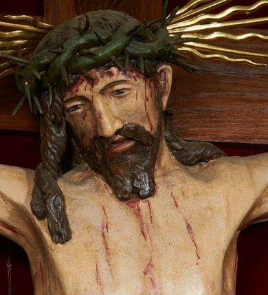 Zdjęcie nr 7: Krzyż drewniany o prostych ramionach z figurą w typie Cristo vivo przybitą trzema gwoździami. Sylwetka w lekkim zwisie, o szerokim rozłożeniu ramion, z głową przechyloną na prawe ramię; nogi ugięte w kolanach, skierowane w prawą stronę, stopy w układzie prawa na lewą. Twarz pociągła o wąskich, otwartych oczach, dużym nosie, otwartych ustach, okolona brodą oraz włosami skręconymi w rurkowate pukle. Na głowie korona cierniowa, wokół niej trzy wiązki promieni. Ciało wychudzone, o zaznaczonych mięśniach ramion i nóg oraz sumarycznie kształtowanej klatce piersiowej z podkreślonymi liniami żeber i wypukłością brzucha oraz ze śladami męki w postaci rzeźbionych kropel krwi wypływającej z ran. Perizonium krótkie, ściśle opinające biodra, zawiązane w partii podbrzusza, ze zwisem na prawym biodrze. Na górnym zakończeniu pionowej belki krzyża banderola z napisem „INRI”. Ciało polichromowane naturalistycznie, perizonium pozłacane. 
