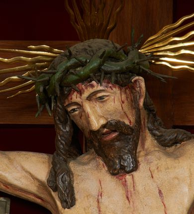 Zdjęcie nr 8: Krzyż drewniany o prostych ramionach z figurą w typie Cristo vivo przybitą trzema gwoździami. Sylwetka w lekkim zwisie, o szerokim rozłożeniu ramion, z głową przechyloną na prawe ramię; nogi ugięte w kolanach, skierowane w prawą stronę, stopy w układzie prawa na lewą. Twarz pociągła o wąskich, otwartych oczach, dużym nosie, otwartych ustach, okolona brodą oraz włosami skręconymi w rurkowate pukle. Na głowie korona cierniowa, wokół niej trzy wiązki promieni. Ciało wychudzone, o zaznaczonych mięśniach ramion i nóg oraz sumarycznie kształtowanej klatce piersiowej z podkreślonymi liniami żeber i wypukłością brzucha oraz ze śladami męki w postaci rzeźbionych kropel krwi wypływającej z ran. Perizonium krótkie, ściśle opinające biodra, zawiązane w partii podbrzusza, ze zwisem na prawym biodrze. Na górnym zakończeniu pionowej belki krzyża banderola z napisem „INRI”. Ciało polichromowane naturalistycznie, perizonium pozłacane. 
