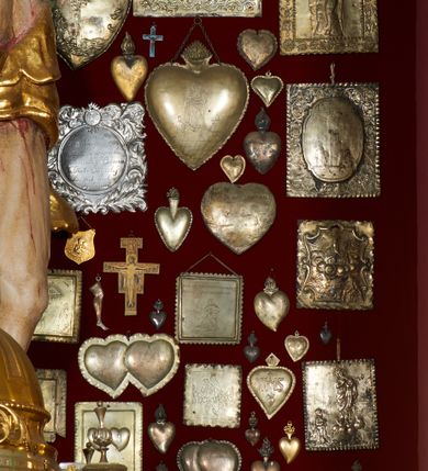 Zdjęcie nr 13: Krzyż drewniany o prostych ramionach z figurą w typie Cristo vivo przybitą trzema gwoździami. Sylwetka w lekkim zwisie, o szerokim rozłożeniu ramion, z głową przechyloną na prawe ramię; nogi ugięte w kolanach, skierowane w prawą stronę, stopy w układzie prawa na lewą. Twarz pociągła o wąskich, otwartych oczach, dużym nosie, otwartych ustach, okolona brodą oraz włosami skręconymi w rurkowate pukle. Na głowie korona cierniowa, wokół niej trzy wiązki promieni. Ciało wychudzone, o zaznaczonych mięśniach ramion i nóg oraz sumarycznie kształtowanej klatce piersiowej z podkreślonymi liniami żeber i wypukłością brzucha oraz ze śladami męki w postaci rzeźbionych kropel krwi wypływającej z ran. Perizonium krótkie, ściśle opinające biodra, zawiązane w partii podbrzusza, ze zwisem na prawym biodrze. Na górnym zakończeniu pionowej belki krzyża banderola z napisem „INRI”. Ciało polichromowane naturalistycznie, perizonium pozłacane. 
