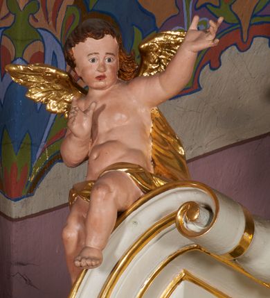 Zdjęcie nr 6: Nastawa ołtarzowa architektoniczna, jednoosiowa, jednokondygnacyjna ze zwieńczeniem, ustawiona na dwustrefowym cokole, z wyodrębnionymi po bokach dwoma prostopadłościennymi postumentami. Ołtarz drewniany, prostopadłościenny. Antepedium w formie poziomego prostokąta w profilowanej ramie, jego powierzchnia podzielona jest wstęgami na trzy owalne pola, wewnątrz każdego wazon z bukietem kwiatów z owocami, dookoła nich w niewielkich polach przedstawienia orłów. Na mensie ustawione tabernakulum w formie prostopadłościennej skrzynki z drzwiczkami w formie pionowego prostokąta, z przedstawieniem hostii w glorii promienistej.
Środkowa część struktury nastawy ujęta parą kolumn kompozytowych na tle zwielokrotnionych pilastrów, ustawionych na wyodrębnionych cokołach dekorowanych rocaille'm. Kolumny dźwigają pełne belkowanie wyłamane na ich osi oraz odcinki przerwanego, falistego przyczółka, na którym siedzą putta. W polu środkowym obraz z przedstawieniem Matki Boskiej Niepokalanie Poczętej ze św. Heleną i św. Wojciechem w formie pionowego prostokąta zamkniętego łukiem półkolistym, w profilowanej ramie dekorowanej rocaille'm. Nad obrazem, w partii belkowania rocaille'owy kartusz z napisem „TOTA / PULCHRA EST MARIA / ET MACULA ORDINATIS/ IN TE”. Po zewnętrznej stronie kolumn na wspornikach stoją figury św. Anny i św. Joachima. Ołtarz flankowany uszami utworzonymi z motywów rocaille. Zwieńczenie w formie trapezu ujętego spływami wolutowymi, zamkniętego łukiem półkolistym nadwieszonym, obwiedzionego profilowanymi listwami, zwieńczonego gzymsem, dekorowanym rocaiile'owym kartuszem i ornamentem roślinnym. W polu powtarzającym kształt zwieńczenia obraz Narodzenia Marii w profilowanej ramie. Struktura ołtarza polichromowana w kolorze bieli, ornamentyka, profile i kolumny pozłacane.





