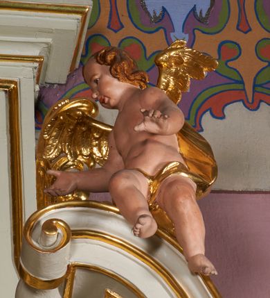 Zdjęcie nr 8: Nastawa ołtarzowa architektoniczna, jednoosiowa, jednokondygnacyjna ze zwieńczeniem, ustawiona na dwustrefowym cokole, z wyodrębnionymi po bokach dwoma prostopadłościennymi postumentami. Ołtarz drewniany, prostopadłościenny. Antepedium w formie poziomego prostokąta w profilowanej ramie, jego powierzchnia podzielona jest wstęgami na trzy owalne pola, wewnątrz każdego wazon z bukietem kwiatów z owocami, dookoła nich w niewielkich polach przedstawienia orłów. Na mensie ustawione tabernakulum w formie prostopadłościennej skrzynki z drzwiczkami w formie pionowego prostokąta, z przedstawieniem hostii w glorii promienistej.
Środkowa część struktury nastawy ujęta parą kolumn kompozytowych na tle zwielokrotnionych pilastrów, ustawionych na wyodrębnionych cokołach dekorowanych rocaille'm. Kolumny dźwigają pełne belkowanie wyłamane na ich osi oraz odcinki przerwanego, falistego przyczółka, na którym siedzą putta. W polu środkowym obraz z przedstawieniem Matki Boskiej Niepokalanie Poczętej ze św. Heleną i św. Wojciechem w formie pionowego prostokąta zamkniętego łukiem półkolistym, w profilowanej ramie dekorowanej rocaille'm. Nad obrazem, w partii belkowania rocaille'owy kartusz z napisem „TOTA / PULCHRA EST MARIA / ET MACULA ORDINATIS/ IN TE”. Po zewnętrznej stronie kolumn na wspornikach stoją figury św. Anny i św. Joachima. Ołtarz flankowany uszami utworzonymi z motywów rocaille. Zwieńczenie w formie trapezu ujętego spływami wolutowymi, zamkniętego łukiem półkolistym nadwieszonym, obwiedzionego profilowanymi listwami, zwieńczonego gzymsem, dekorowanym rocaiile'owym kartuszem i ornamentem roślinnym. W polu powtarzającym kształt zwieńczenia obraz Narodzenia Marii w profilowanej ramie. Struktura ołtarza polichromowana w kolorze bieli, ornamentyka, profile i kolumny pozłacane.





