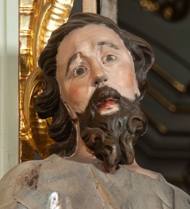 Zdjęcie nr 15: Nastawa ołtarzowa architektoniczna, jednoosiowa, jednokondygnacyjna ze zwieńczeniem, ustawiona na dwustrefowym cokole, z wyodrębnionymi po bokach dwoma prostopadłościennymi postumentami. Ołtarz drewniany, prostopadłościenny. Antepedium w formie poziomego prostokąta w profilowanej ramie, jego powierzchnia podzielona jest wstęgami na trzy owalne pola, wewnątrz każdego wazon z bukietem kwiatów z owocami, dookoła nich w niewielkich polach przedstawienia orłów. Na mensie ustawione tabernakulum w formie prostopadłościennej skrzynki z drzwiczkami w formie pionowego prostokąta, z przedstawieniem hostii w glorii promienistej.
Środkowa część struktury nastawy ujęta parą kolumn kompozytowych na tle zwielokrotnionych pilastrów, ustawionych na wyodrębnionych cokołach dekorowanych rocaille'm. Kolumny dźwigają pełne belkowanie wyłamane na ich osi oraz odcinki przerwanego, falistego przyczółka, na którym siedzą putta. W polu środkowym obraz z przedstawieniem Matki Boskiej Niepokalanie Poczętej ze św. Heleną i św. Wojciechem w formie pionowego prostokąta zamkniętego łukiem półkolistym, w profilowanej ramie dekorowanej rocaille'm. Nad obrazem, w partii belkowania rocaille'owy kartusz z napisem „TOTA / PULCHRA EST MARIA / ET MACULA ORDINATIS/ IN TE”. Po zewnętrznej stronie kolumn na wspornikach stoją figury św. Anny i św. Joachima. Ołtarz flankowany uszami utworzonymi z motywów rocaille. Zwieńczenie w formie trapezu ujętego spływami wolutowymi, zamkniętego łukiem półkolistym nadwieszonym, obwiedzionego profilowanymi listwami, zwieńczonego gzymsem, dekorowanym rocaiile'owym kartuszem i ornamentem roślinnym. W polu powtarzającym kształt zwieńczenia obraz Narodzenia Marii w profilowanej ramie. Struktura ołtarza polichromowana w kolorze bieli, ornamentyka, profile i kolumny pozłacane.





