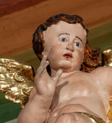 Zdjęcie nr 7: Nastawa ołtarzowa architektoniczna, jednoosiowa, jednokondygnacyjna ze zwieńczeniem, ustawiona na dwustrefowym cokole, z wyodrębnionymi po bokach dwoma prostopadłościennymi postumentami. Ołtarz drewniany, prostopadłościenny. Antepedium w formie poziomego prostokąta w profilowanej ramie, jego powierzchnia podzielona jest wstęgami na trzy owalne pola, wewnątrz każdego wazon z bukietem kwiatów z owocami, dookoła nich w niewielkich polach przedstawienia orłów. Na mensie ustawione tabernakulum w formie prostopadłościennej skrzynki z drzwiczkami w formie pionowego prostokąta, z przedstawieniem hostii w glorii promienistej.
Środkowa część struktury nastawy ujęta parą kolumn kompozytowych na tle zwielokrotnionych pilastrów, ustawionych na wyodrębnionych cokołach dekorowanych rocaille'm. Kolumny dźwigają pełne belkowanie wyłamane na ich osi oraz odcinki przerwanego, falistego przyczółka, na którym siedzą putta. W polu środkowym obraz z przedstawieniem Matki Boskiej Niepokalanie Poczętej ze św. Heleną i św. Wojciechem w formie pionowego prostokąta zamkniętego łukiem półkolistym, w profilowanej ramie dekorowanej rocaille'm. Nad obrazem, w partii belkowania rocaille'owy kartusz z napisem „TOTA / PULCHRA EST MARIA / ET MACULA ORDINATIS/ IN TE”. Po zewnętrznej stronie kolumn na wspornikach stoją figury św. Anny i św. Joachima. Ołtarz flankowany uszami utworzonymi z motywów rocaille. Zwieńczenie w formie trapezu ujętego spływami wolutowymi, zamkniętego łukiem półkolistym nadwieszonym, obwiedzionego profilowanymi listwami, zwieńczonego gzymsem, dekorowanym rocaiile'owym kartuszem i ornamentem roślinnym. W polu powtarzającym kształt zwieńczenia obraz Narodzenia Marii w profilowanej ramie. Struktura ołtarza polichromowana w kolorze bieli, ornamentyka, profile i kolumny pozłacane.





