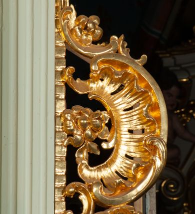 Zdjęcie nr 13: Nastawa ołtarzowa architektoniczna, jednoosiowa, jednokondygnacyjna ze zwieńczeniem, ustawiona na dwustrefowym cokole, z wyodrębnionymi po bokach dwoma prostopadłościennymi postumentami. Ołtarz drewniany, prostopadłościenny. Antepedium w formie poziomego prostokąta w profilowanej ramie, jego powierzchnia podzielona jest wstęgami na trzy owalne pola, wewnątrz każdego wazon z bukietem kwiatów z owocami, dookoła nich w niewielkich polach przedstawienia orłów. Na mensie ustawione tabernakulum w formie prostopadłościennej skrzynki z drzwiczkami w formie pionowego prostokąta, z przedstawieniem hostii w glorii promienistej.
Środkowa część struktury nastawy ujęta parą kolumn kompozytowych na tle zwielokrotnionych pilastrów, ustawionych na wyodrębnionych cokołach dekorowanych rocaille&#039;m. Kolumny dźwigają pełne belkowanie wyłamane na ich osi oraz odcinki przerwanego, falistego przyczółka, na którym siedzą putta. W polu środkowym obraz z przedstawieniem Matki Boskiej Niepokalanie Poczętej ze św. Heleną i św. Wojciechem w formie pionowego prostokąta zamkniętego łukiem półkolistym, w profilowanej ramie dekorowanej rocaille&#039;m. Nad obrazem, w partii belkowania rocaille&#039;owy kartusz z napisem „TOTA / PULCHRA EST MARIA / ET MACULA ORDINATIS/ IN TE”. Po zewnętrznej stronie kolumn na wspornikach stoją figury św. Anny i św. Joachima. Ołtarz flankowany uszami utworzonymi z motywów rocaille. Zwieńczenie w formie trapezu ujętego spływami wolutowymi, zamkniętego łukiem półkolistym nadwieszonym, obwiedzionego profilowanymi listwami, zwieńczonego gzymsem, dekorowanym rocaiile&#039;owym kartuszem i ornamentem roślinnym. W polu powtarzającym kształt zwieńczenia obraz Narodzenia Marii w profilowanej ramie. Struktura ołtarza polichromowana w kolorze bieli, ornamentyka, profile i kolumny pozłacane.





