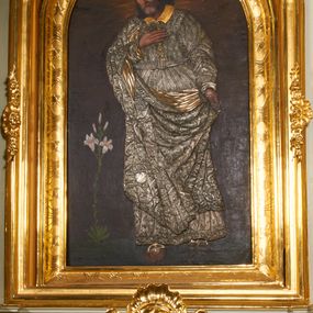 Zdjęcie nr 1: Obraz w kształcie stojącego prostokąta, zamkniętego łukiem półkolistym. W centrum kompozycji ukazany św. Józef w postawie stojącej, delikatnie zwrócony w prawą stronę, z prawą stopą wysuniętą do przodu a prawą ręką złożoną na piersi, zaś lewą ręką przytrzymujący połę płaszcza u boku. Twarz świętego owalna, z długim i prostym nosem, okolona siwą brodą oraz długimi i delikatnie siwymi włosami, opadającymi na ramiona. Postać przykryta metalową sukienką w kolorze srebra, na powierzchni której oddano przebieg draperii szat świętego oraz zdobiący je ornament roślinny, a nad głową złoconą, kameryzowaną i promienistą koronę. Tło jednolite, brunatne, wokół głowy św. Józefa delikatnie rozjaśnione na kształt nimbu. Po lewej stronie obrazu krzak białej lilii. 


