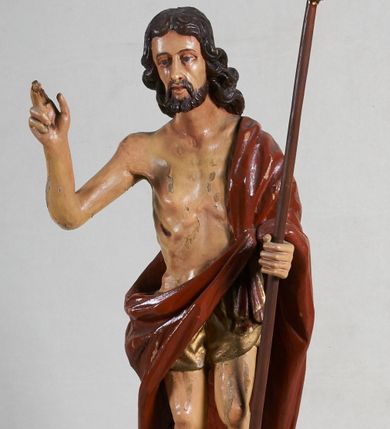 Zdjęcie nr 1: Rzeźba pełna, ustawiona jest na niskiej podstawie w formie płyty oraz na wypukłym postumencie imitującym fragment gruntu. Chrystus ukazany jest w całej postaci, frontalnie, w wykroku, z prawą ręką uniesioną w geście błogosławieństwa, w lewej trzyma drzewce zakończone krzyżem, z brakującą chorągwią. Jego twarz jest szczupła i pociągła, o dużych oczach, prostym nosie i pełnych ustach, okolona krótką, brązową brodą skręconą w dwa pukle oraz brązowymi, silnie kręconymi włosami opadającymi na plecy. Biodra Chrystusa przepasane są krótkim perizonium, zaś na jego lewym ramieniu zawieszony jest czerwony płaszcz, który otacza diagonalnie postać i zarzucony jest z przodu postaci na lewym przedramieniu, odsłaniając tors i nogi. Ciało bardzo wychudzone, o podkreślonych liniach żeber i mostka klatki piersiowej, z zaznaczonymi śladami męki. Polichromia ciała jest naturalistyczna, perizonium pozłacane, a drzewce pomalowane na kolor brązowy.



