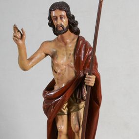 Zdjęcie nr 1: Rzeźba pełna, ustawiona jest na niskiej podstawie w formie płyty oraz na wypukłym postumencie imitującym fragment gruntu. Chrystus ukazany jest w całej postaci, frontalnie, w wykroku, z prawą ręką uniesioną w geście błogosławieństwa, w lewej trzyma drzewce zakończone krzyżem, z brakującą chorągwią. Jego twarz jest szczupła i pociągła, o dużych oczach, prostym nosie i pełnych ustach, okolona krótką, brązową brodą skręconą w dwa pukle oraz brązowymi, silnie kręconymi włosami opadającymi na plecy. Biodra Chrystusa przepasane są krótkim perizonium, zaś na jego lewym ramieniu zawieszony jest czerwony płaszcz, który otacza diagonalnie postać i zarzucony jest z przodu postaci na lewym przedramieniu, odsłaniając tors i nogi. Ciało bardzo wychudzone, o podkreślonych liniach żeber i mostka klatki piersiowej, z zaznaczonymi śladami męki. Polichromia ciała jest naturalistyczna, perizonium pozłacane, a drzewce pomalowane na kolor brązowy.



