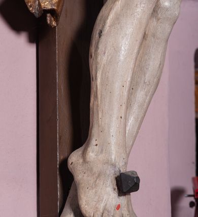 Zdjęcie nr 8: Figura umarłego Chrystusa została przybita do prostego krzyża trzema gwoździami. Jego ciało ukazane jest w lekkim zwisie, o niemal horyzontalnie rozłożonych ramionach, z głową opadającą na prawy bark, z lekko ugiętymi kolanami i stopami skrzyżowanymi w układzie prawa na lewą. Twarz Chrystusa jest szczupła, zwężająca się mocno ku dołowi, z okrągłymi, zamkniętymi oczami, z niewielkim, wąskim nosem i z małymi, rozchylonymi ustami, okolona krótką brązową, brodą, układającą się w dwa pukle oraz brązowymi, kręconym włosami opadającymi na prawe ramię. Ciało Chrystusa jest szczupłe, o delikatnym modelunku, z zaznaczoną muskulaturą ramion i nóg, z wyraźnie zarysowanymi żebrami i mostkiem klatki piersiowej. Perizonium zawieszone na sznurze, częściowo odsłaniające biodra i prawe udo, ze zwisem tkaniny opadającym wzdłuż prawego boku Chrystusa. Na głowie korona cierniowa. Na górnym zakończeniu pionowej belki krzyża kartusz z napisem „I.N.R.I.”. Polichromia karnacji ciała naturalistyczna, z zaznaczonymi śladami męki, tkanina perizonium i korona cierniowa pozłacane. 
