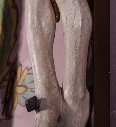 Zdjęcie nr 9: Figura umarłego Chrystusa została przybita do prostego krzyża trzema gwoździami. Jego ciało ukazane jest w lekkim zwisie, o niemal horyzontalnie rozłożonych ramionach, z głową opadającą na prawy bark, z lekko ugiętymi kolanami i stopami skrzyżowanymi w układzie prawa na lewą. Twarz Chrystusa jest szczupła, zwężająca się mocno ku dołowi, z okrągłymi, zamkniętymi oczami, z niewielkim, wąskim nosem i z małymi, rozchylonymi ustami, okolona krótką brązową, brodą, układającą się w dwa pukle oraz brązowymi, kręconym włosami opadającymi na prawe ramię. Ciało Chrystusa jest szczupłe, o delikatnym modelunku, z zaznaczoną muskulaturą ramion i nóg, z wyraźnie zarysowanymi żebrami i mostkiem klatki piersiowej. Perizonium zawieszone na sznurze, częściowo odsłaniające biodra i prawe udo, ze zwisem tkaniny opadającym wzdłuż prawego boku Chrystusa. Na głowie korona cierniowa. Na górnym zakończeniu pionowej belki krzyża kartusz z napisem „I.N.R.I.”. Polichromia karnacji ciała naturalistyczna, z zaznaczonymi śladami męki, tkanina perizonium i korona cierniowa pozłacane. 
