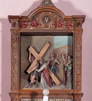 Zdjęcie nr 9: Stacje Drogi krzyżowej w kształcie stojących prostokątów zostały ujęte architektoniczną ramą. Obrazy ustawiono na cokole, po bokach są flankowane dwoma pilastrami, podtrzymującymi wyłamane belkowanie, zamknięte gzymsem w kształcie łuku nadwieszonego. Na szczycie, w rzeźbionych owocach winogron osadzono grecki krzyżyk o trójlistnie zakończonych ramionach z uskokami. Pilastry są zdobione symetryczną wicią cierniową, a pole zwieńczenia bogato dekorowane wicią roślinną złożoną z bujnych, czerwonych kwiatów otaczających numer stacji umieszczony w owalu na tle krzyżyka greckiego. 
Sceny przeważnie wielopostaciowe, płaskorzeźbione, barwnie polichromowane. Postacie o poprawnej anatomii ciała, poruszone, na pierwszym planie bardziej wypukłe. Tło błękitne, malowane. W partii cokołu umieszczono malowane tytuły stacji:
I. „JEZUS NA ŚMIERĆ OSĄDZONY.”
II. „JEZUS BIERZE KRZYŻ NA RAMIONA.”
III. „JEZUS PIERWSZY RAZ UPADA.”
IV. „JEZUS SPOTYKA NAJŚW(IĘTSZĄ) MATKĘ SWOJĄ”
V. „SZYMON CYR(ENEJCZYK) POMAGA NIEŚĆ KRZYŻ JEZUSA”
VI. „ŚW(IĘTA) WERONIKA OCIERA TWARZ JEZUSA”
VII. „JEZUS DRUGI RAZ UPADA”
VIII. „JEZUS NAPOTYKA PŁACZĄCE NIEWIASTY”
IX. „JEZUS TRZECI RAZ UPADA.”
X. „JEZUS Z SZAT OBNAŻONY”
XI. „JEZUS DO KRZYŻA PRZYBITY”
XII. „JEZUS NA KRZYŻU UMIERA.”
XIII. „JEZUS Z KRZYŻA ZDJĘTY.”
XIV. „JEZUS DO GROBU ZŁOŻONY.”
