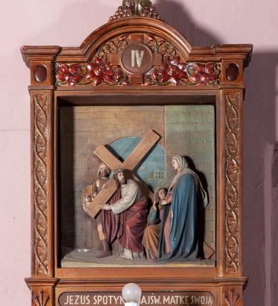 Zdjęcie nr 8: Stacje Drogi krzyżowej w kształcie stojących prostokątów zostały ujęte architektoniczną ramą. Obrazy ustawiono na cokole, po bokach są flankowane dwoma pilastrami, podtrzymującymi wyłamane belkowanie, zamknięte gzymsem w kształcie łuku nadwieszonego. Na szczycie, w rzeźbionych owocach winogron osadzono grecki krzyżyk o trójlistnie zakończonych ramionach z uskokami. Pilastry są zdobione symetryczną wicią cierniową, a pole zwieńczenia bogato dekorowane wicią roślinną złożoną z bujnych, czerwonych kwiatów otaczających numer stacji umieszczony w owalu na tle krzyżyka greckiego. 
Sceny przeważnie wielopostaciowe, płaskorzeźbione, barwnie polichromowane. Postacie o poprawnej anatomii ciała, poruszone, na pierwszym planie bardziej wypukłe. Tło błękitne, malowane. W partii cokołu umieszczono malowane tytuły stacji:
I. „JEZUS NA ŚMIERĆ OSĄDZONY.”
II. „JEZUS BIERZE KRZYŻ NA RAMIONA.”
III. „JEZUS PIERWSZY RAZ UPADA.”
IV. „JEZUS SPOTYKA NAJŚW(IĘTSZĄ) MATKĘ SWOJĄ”
V. „SZYMON CYR(ENEJCZYK) POMAGA NIEŚĆ KRZYŻ JEZUSA”
VI. „ŚW(IĘTA) WERONIKA OCIERA TWARZ JEZUSA”
VII. „JEZUS DRUGI RAZ UPADA”
VIII. „JEZUS NAPOTYKA PŁACZĄCE NIEWIASTY”
IX. „JEZUS TRZECI RAZ UPADA.”
X. „JEZUS Z SZAT OBNAŻONY”
XI. „JEZUS DO KRZYŻA PRZYBITY”
XII. „JEZUS NA KRZYŻU UMIERA.”
XIII. „JEZUS Z KRZYŻA ZDJĘTY.”
XIV. „JEZUS DO GROBU ZŁOŻONY.”
