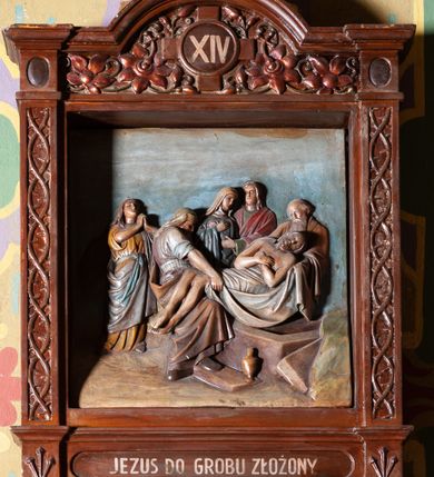 Zdjęcie nr 6: Stacje Drogi krzyżowej w kształcie stojących prostokątów zostały ujęte architektoniczną ramą. Obrazy ustawiono na cokole, po bokach są flankowane dwoma pilastrami, podtrzymującymi wyłamane belkowanie, zamknięte gzymsem w kształcie łuku nadwieszonego. Na szczycie, w rzeźbionych owocach winogron osadzono grecki krzyżyk o trójlistnie zakończonych ramionach z uskokami. Pilastry są zdobione symetryczną wicią cierniową, a pole zwieńczenia bogato dekorowane wicią roślinną złożoną z bujnych, czerwonych kwiatów otaczających numer stacji umieszczony w owalu na tle krzyżyka greckiego. 
Sceny przeważnie wielopostaciowe, płaskorzeźbione, barwnie polichromowane. Postacie o poprawnej anatomii ciała, poruszone, na pierwszym planie bardziej wypukłe. Tło błękitne, malowane. W partii cokołu umieszczono malowane tytuły stacji:
I. „JEZUS NA ŚMIERĆ OSĄDZONY.”
II. „JEZUS BIERZE KRZYŻ NA RAMIONA.”
III. „JEZUS PIERWSZY RAZ UPADA.”
IV. „JEZUS SPOTYKA NAJŚW(IĘTSZĄ) MATKĘ SWOJĄ”
V. „SZYMON CYR(ENEJCZYK) POMAGA NIEŚĆ KRZYŻ JEZUSA”
VI. „ŚW(IĘTA) WERONIKA OCIERA TWARZ JEZUSA”
VII. „JEZUS DRUGI RAZ UPADA”
VIII. „JEZUS NAPOTYKA PŁACZĄCE NIEWIASTY”
IX. „JEZUS TRZECI RAZ UPADA.”
X. „JEZUS Z SZAT OBNAŻONY”
XI. „JEZUS DO KRZYŻA PRZYBITY”
XII. „JEZUS NA KRZYŻU UMIERA.”
XIII. „JEZUS Z KRZYŻA ZDJĘTY.”
XIV. „JEZUS DO GROBU ZŁOŻONY.”
