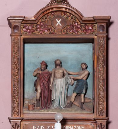 Zdjęcie nr 14: Stacje Drogi krzyżowej w kształcie stojących prostokątów zostały ujęte architektoniczną ramą. Obrazy ustawiono na cokole, po bokach są flankowane dwoma pilastrami, podtrzymującymi wyłamane belkowanie, zamknięte gzymsem w kształcie łuku nadwieszonego. Na szczycie, w rzeźbionych owocach winogron osadzono grecki krzyżyk o trójlistnie zakończonych ramionach z uskokami. Pilastry są zdobione symetryczną wicią cierniową, a pole zwieńczenia bogato dekorowane wicią roślinną złożoną z bujnych, czerwonych kwiatów otaczających numer stacji umieszczony w owalu na tle krzyżyka greckiego. 
Sceny przeważnie wielopostaciowe, płaskorzeźbione, barwnie polichromowane. Postacie o poprawnej anatomii ciała, poruszone, na pierwszym planie bardziej wypukłe. Tło błękitne, malowane. W partii cokołu umieszczono malowane tytuły stacji:
I. „JEZUS NA ŚMIERĆ OSĄDZONY.”
II. „JEZUS BIERZE KRZYŻ NA RAMIONA.”
III. „JEZUS PIERWSZY RAZ UPADA.”
IV. „JEZUS SPOTYKA NAJŚW(IĘTSZĄ) MATKĘ SWOJĄ”
V. „SZYMON CYR(ENEJCZYK) POMAGA NIEŚĆ KRZYŻ JEZUSA”
VI. „ŚW(IĘTA) WERONIKA OCIERA TWARZ JEZUSA”
VII. „JEZUS DRUGI RAZ UPADA”
VIII. „JEZUS NAPOTYKA PŁACZĄCE NIEWIASTY”
IX. „JEZUS TRZECI RAZ UPADA.”
X. „JEZUS Z SZAT OBNAŻONY”
XI. „JEZUS DO KRZYŻA PRZYBITY”
XII. „JEZUS NA KRZYŻU UMIERA.”
XIII. „JEZUS Z KRZYŻA ZDJĘTY.”
XIV. „JEZUS DO GROBU ZŁOŻONY.”
