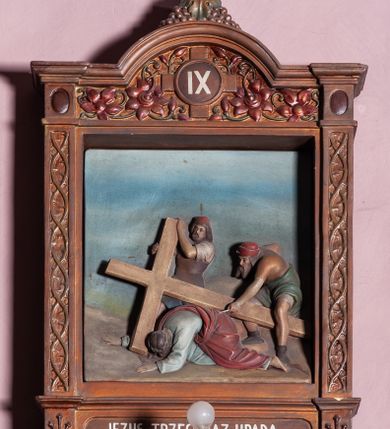 Zdjęcie nr 13: Stacje Drogi krzyżowej w kształcie stojących prostokątów zostały ujęte architektoniczną ramą. Obrazy ustawiono na cokole, po bokach są flankowane dwoma pilastrami, podtrzymującymi wyłamane belkowanie, zamknięte gzymsem w kształcie łuku nadwieszonego. Na szczycie, w rzeźbionych owocach winogron osadzono grecki krzyżyk o trójlistnie zakończonych ramionach z uskokami. Pilastry są zdobione symetryczną wicią cierniową, a pole zwieńczenia bogato dekorowane wicią roślinną złożoną z bujnych, czerwonych kwiatów otaczających numer stacji umieszczony w owalu na tle krzyżyka greckiego. 
Sceny przeważnie wielopostaciowe, płaskorzeźbione, barwnie polichromowane. Postacie o poprawnej anatomii ciała, poruszone, na pierwszym planie bardziej wypukłe. Tło błękitne, malowane. W partii cokołu umieszczono malowane tytuły stacji:
I. „JEZUS NA ŚMIERĆ OSĄDZONY.”
II. „JEZUS BIERZE KRZYŻ NA RAMIONA.”
III. „JEZUS PIERWSZY RAZ UPADA.”
IV. „JEZUS SPOTYKA NAJŚW(IĘTSZĄ) MATKĘ SWOJĄ”
V. „SZYMON CYR(ENEJCZYK) POMAGA NIEŚĆ KRZYŻ JEZUSA”
VI. „ŚW(IĘTA) WERONIKA OCIERA TWARZ JEZUSA”
VII. „JEZUS DRUGI RAZ UPADA”
VIII. „JEZUS NAPOTYKA PŁACZĄCE NIEWIASTY”
IX. „JEZUS TRZECI RAZ UPADA.”
X. „JEZUS Z SZAT OBNAŻONY”
XI. „JEZUS DO KRZYŻA PRZYBITY”
XII. „JEZUS NA KRZYŻU UMIERA.”
XIII. „JEZUS Z KRZYŻA ZDJĘTY.”
XIV. „JEZUS DO GROBU ZŁOŻONY.”
