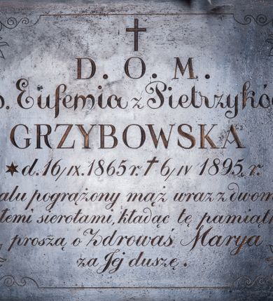 Zdjęcie nr 1: Płyta epitafijna w kształcie leżącego prostokąta, obwiedziona linią przechodzącą w narożach w stylizowane akroteriony. W polu kuta, złocona inskrypcja „D(EO) O(PTIMO) M(AXIMO) / ś(więtej) p(amięci) Eufemia z Pietrzyków / GRZYBOWSKA / d(nia) * 16/IX. 1865 r(oku) + 6/IV 1895 r(oku) / w żalu pogrążony mąż wraz z dwoma / małemi sierotami, kładąc tę pamiątkę / proszą o Zdrowaś Marya / za Jej duszę”.