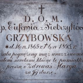 Zdjęcie nr 1: Płyta epitafijna w kształcie leżącego prostokąta, obwiedziona linią przechodzącą w narożach w stylizowane akroteriony. W polu kuta, złocona inskrypcja „D(EO) O(PTIMO) M(AXIMO) / ś(więtej) p(amięci) Eufemia z Pietrzyków / GRZYBOWSKA / d(nia) * 16/IX. 1865 r(oku) + 6/IV 1895 r(oku) / w żalu pogrążony mąż wraz z dwoma / małemi sierotami, kładąc tę pamiątkę / proszą o Zdrowaś Marya / za Jej duszę”.