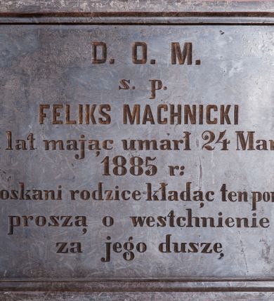 Zdjęcie nr 1: Płyta epitafijna w kształcie leżącego prostokąta, na brzegach profilowana. W polu kuta inskrypcja „D(EO) O(PTIMO) M(AXIMO) / s(więtej) p(amięci) / FELIKS MACHNICKI / 19 lat mając umarł 24 Marca / 1885 r(oku) / stroskani rodzice kładąc ten pomnik / proszą o westchnienie / za jego duszę”.
