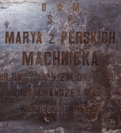 Zdjęcie nr 1: Tablica epitafijna w kształcie leżącego prostokąta. W polu kuta inskrypcja „D[EO] O[PTIMO] M[AXIMO] / Ś(WIĘTEJ) P(AMIĘCI) MARYA Z PERSKICH / MACHNICKA / UR(ODZONA) DN(IA) 24/III 1824. ZM(ARŁA) DN(IA) 23/III 1865 / NAJUKOCHAŃSZEJ MATCE / WDZIĘCZNE DZIECI”.