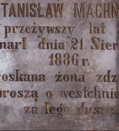 Zdjęcie nr 1: Tablica epitafijna w kształcie leżącego prostokąta, zamknięta łukiem nadwieszonym, profilowana. W polu inskrypcja „D(EO) O(PTIMO) M(AXIMO) / s(więtej) p(amięci) / STANISŁAW MACHNICKI / przeżywszy lat 75 / zmarł dnia 21. Sierpnia / 1886 r(oku) / Stroskana żona z dziećmi / proszą o westchnienie / za Jego duszę”.