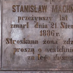 Zdjęcie nr 1: Tablica epitafijna w kształcie leżącego prostokąta, zamknięta łukiem nadwieszonym, profilowana. W polu inskrypcja „D(EO) O(PTIMO) M(AXIMO) / s(więtej) p(amięci) / STANISŁAW MACHNICKI / przeżywszy lat 75 / zmarł dnia 21. Sierpnia / 1886 r(oku) / Stroskana żona z dziećmi / proszą o westchnienie / za Jego duszę”.