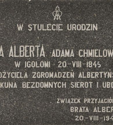 Zdjęcie nr 1: Tablica w kształcie leżącego prostokąta z inskrypcją „W STULECIE URODZIN / BRATA ALBERTA ADAMA CHMIELOWSKIEGO / W IGOŁOMI  20 - VIII - 1845 / ZAŁOŻYCIELA ZGROMADZEŃ ALBERTYŃSKICH / OPIEKUNA BEZDOMNYCH SIEROT I UBOGICH / ZWIĄZEK PRZYJACIÓŁ DZIEŁA / BRATA ALBERTA 20 - VIII - 1945”. Nad inskrypcją znak przedstawiający gorejące serce oraz łaciński krzyż wpisany w literę „A”.