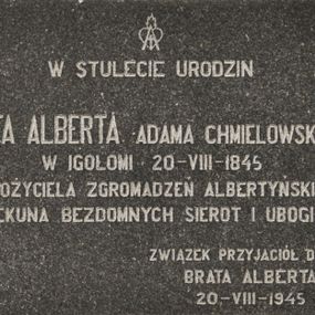 Zdjęcie nr 1: Tablica w kształcie leżącego prostokąta z inskrypcją „W STULECIE URODZIN / BRATA ALBERTA ADAMA CHMIELOWSKIEGO / W IGOŁOMI  20 - VIII - 1845 / ZAŁOŻYCIELA ZGROMADZEŃ ALBERTYŃSKICH / OPIEKUNA BEZDOMNYCH SIEROT I UBOGICH / ZWIĄZEK PRZYJACIÓŁ DZIEŁA / BRATA ALBERTA 20 - VIII - 1945”. Nad inskrypcją znak przedstawiający gorejące serce oraz łaciński krzyż wpisany w literę „A”.