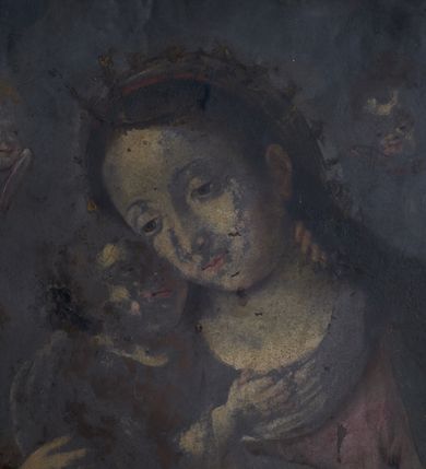 Zdjęcie nr 2: Obraz w kształcie stojącego prostokąta, przedstawiający Matkę Boską z Dzieciątkiem oraz Zaślubiny Marii na odwrociu. Madonna ukazana jest w pozycji siedzącej, widoczna w półpostaci, zwrócona w trzech czwartych w swoją prawą stronę, obejmująca obiema rękami Dzieciątko Jezus. Głowę ma lekko pochyloną w prawą stronę. Twarz okrągła, oczy półprzymknięte, brwi łukowato wygięte. Włosy ciemne, swobodnie opadające na ramiona. Matka Boska odziana jest w czerwoną suknię, na ramiona ma zarzucony ciemnozielony płaszcz, zdobiony na brzegach bordiurą. Na głowie maforium, owinięte też wokół szyi. Dzieciątko ukazane jest w pozycji siedzącej na pieluszce i rękach Marii. Lewą ręką obejmuje Matkę za szyję, prawą ma położoną na jej dekolcie, głowę unosi do góry i przytula do policzka Marii. Włosy krótkie i kręcone. Dzieciątko odziane jest w długą suknię. W tle pięć uskrzydlonych główek aniołków. Na odwrociu scena przedstawiająca Zaślubiny Marii. Pośrodku kompozycji ukazani Maria i Józef, zwróceni ku sobie, trzymający się za dłonie. Pomiędzy nimi kapłan udzielający ślubu. Za plecami Matki Boskiej widoczna kobieta, za plecami św. Józefa dwaj mężczyźni. Pozostałe elementy kompozycji nieczytelne, z powodu dużego zniszczenia dzieła.