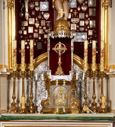 Zdjęcie nr 2: Tabernakulum w formie skrzynki, na cokole, z wybrzuszonym licem, z korpusem flankowanym ustawionymi ukośnie pilastrami, dźwigającymi gzyms, o trzonach przechodzących dołem w spływy wolutowe dekorowane motywami rocaille. Drzwiczki kwadratowe, zamknięte od góry półkoliście, ujęte ramą dekorowaną ornamentem roślinnym, w polu aplikowany kielich eucharystyczny w otoczeniu kłosów zbóż i kiści winogron. Na tabernakulum tron wystawienia utworzony ze ścianki wyłożonej czerwonym atłasem flankowanej kolumienkami dekorowanymi liśćmi akantu, ustawionymi na postumentach i dźwigającymi podwójne imposty i stojące na nich wazoniki. Całość zwieńczona baldachimem w formie kopuły zakończonej krzyżem, na planie analogicznym do tabernakulum, z podwieszonym stylizowanym lambrekinem. Drewniana struktura tabernakulum pozłacana, tron posrebrzany i pozłacany.

