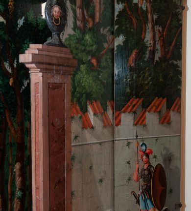 Zdjęcie nr 14: Oprawa grobu Pańskiego kulisowa, pięciopłaszczyznowa. Pierwszy plan tworzy iluzjonistyczna dekoracja, utworzona z bramy składającej się z dwóch filarów zwieńczonych wazonami z antabami oraz muru z krenelażem. Na tle muru ukazani dwaj rzymscy legioniści, po lewej stronie siedzący, po prawej stojący. W tle bogata roślinność egzotyczna z palmami. Na pozostałych planach namalowana roślinność leśna z egzotycznymi gatunkami palm. Na trzeciej parze kulis  przedstawieni dwaj rzymscy legioniści, lewy w pozycji stojącej, prawy leżącej, z głową wspartą na ręce. Wszystkie cztery płaszczyzny zamknięte łukami z namalowanym błękitnym niebem z gwiazdami, ujętym obłokami. 
Na ścianie zamykającej dekorację ukazano kamienny grób, po bokach którego siedzi i leży po trzech legionistów rzymskich z każdej strony. Nad nimi namalowane zalesione wzgórze Golgoty z trzema krzyżami, przed którymi stoi płaczący anioł. W tle widoczny jest pejzaż Jerozolimy, nad którym ukazano zaćmione słońce. W górnej części ściany ukazano niebo z nałożonym medalionem utworzonym z obłoków, z dwiema uskrzydlonymi główkami anielskimi, w glorii promienistej. 



