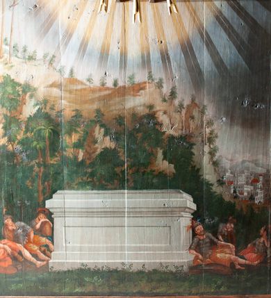 Zdjęcie nr 3: Oprawa grobu Pańskiego kulisowa, pięciopłaszczyznowa. Pierwszy plan tworzy iluzjonistyczna dekoracja, utworzona z bramy składającej się z dwóch filarów zwieńczonych wazonami z antabami oraz muru z krenelażem. Na tle muru ukazani dwaj rzymscy legioniści, po lewej stronie siedzący, po prawej stojący. W tle bogata roślinność egzotyczna z palmami. Na pozostałych planach namalowana roślinność leśna z egzotycznymi gatunkami palm. Na trzeciej parze kulis  przedstawieni dwaj rzymscy legioniści, lewy w pozycji stojącej, prawy leżącej, z głową wspartą na ręce. Wszystkie cztery płaszczyzny zamknięte łukami z namalowanym błękitnym niebem z gwiazdami, ujętym obłokami. 
Na ścianie zamykającej dekorację ukazano kamienny grób, po bokach którego siedzi i leży po trzech legionistów rzymskich z każdej strony. Nad nimi namalowane zalesione wzgórze Golgoty z trzema krzyżami, przed którymi stoi płaczący anioł. W tle widoczny jest pejzaż Jerozolimy, nad którym ukazano zaćmione słońce. W górnej części ściany ukazano niebo z nałożonym medalionem utworzonym z obłoków, z dwiema uskrzydlonymi główkami anielskimi, w glorii promienistej. 



