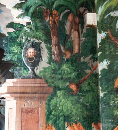 Zdjęcie nr 18: Oprawa grobu Pańskiego kulisowa, pięciopłaszczyznowa. Pierwszy plan tworzy iluzjonistyczna dekoracja, utworzona z bramy składającej się z dwóch filarów zwieńczonych wazonami z antabami oraz muru z krenelażem. Na tle muru ukazani dwaj rzymscy legioniści, po lewej stronie siedzący, po prawej stojący. W tle bogata roślinność egzotyczna z palmami. Na pozostałych planach namalowana roślinność leśna z egzotycznymi gatunkami palm. Na trzeciej parze kulis  przedstawieni dwaj rzymscy legioniści, lewy w pozycji stojącej, prawy leżącej, z głową wspartą na ręce. Wszystkie cztery płaszczyzny zamknięte łukami z namalowanym błękitnym niebem z gwiazdami, ujętym obłokami. 
Na ścianie zamykającej dekorację ukazano kamienny grób, po bokach którego siedzi i leży po trzech legionistów rzymskich z każdej strony. Nad nimi namalowane zalesione wzgórze Golgoty z trzema krzyżami, przed którymi stoi płaczący anioł. W tle widoczny jest pejzaż Jerozolimy, nad którym ukazano zaćmione słońce. W górnej części ściany ukazano niebo z nałożonym medalionem utworzonym z obłoków, z dwiema uskrzydlonymi główkami anielskimi, w glorii promienistej. 



